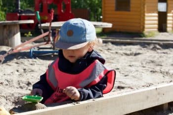 enfant jouant dans un bac à sable à la crèche