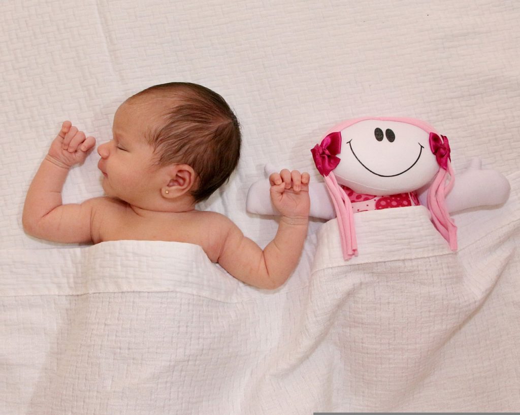 Bébé et sa peluche produisant des bruits blancs pour l'aider à s'endormir