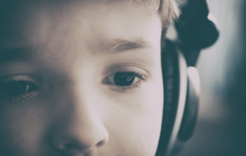 photo d'un enfant ecoutant un livre audio à l'aide d'un casque audio