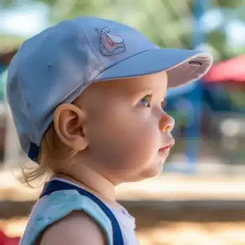 bébé équipé pour se protéger du soleil avec une casquette et des vêtements adaptés