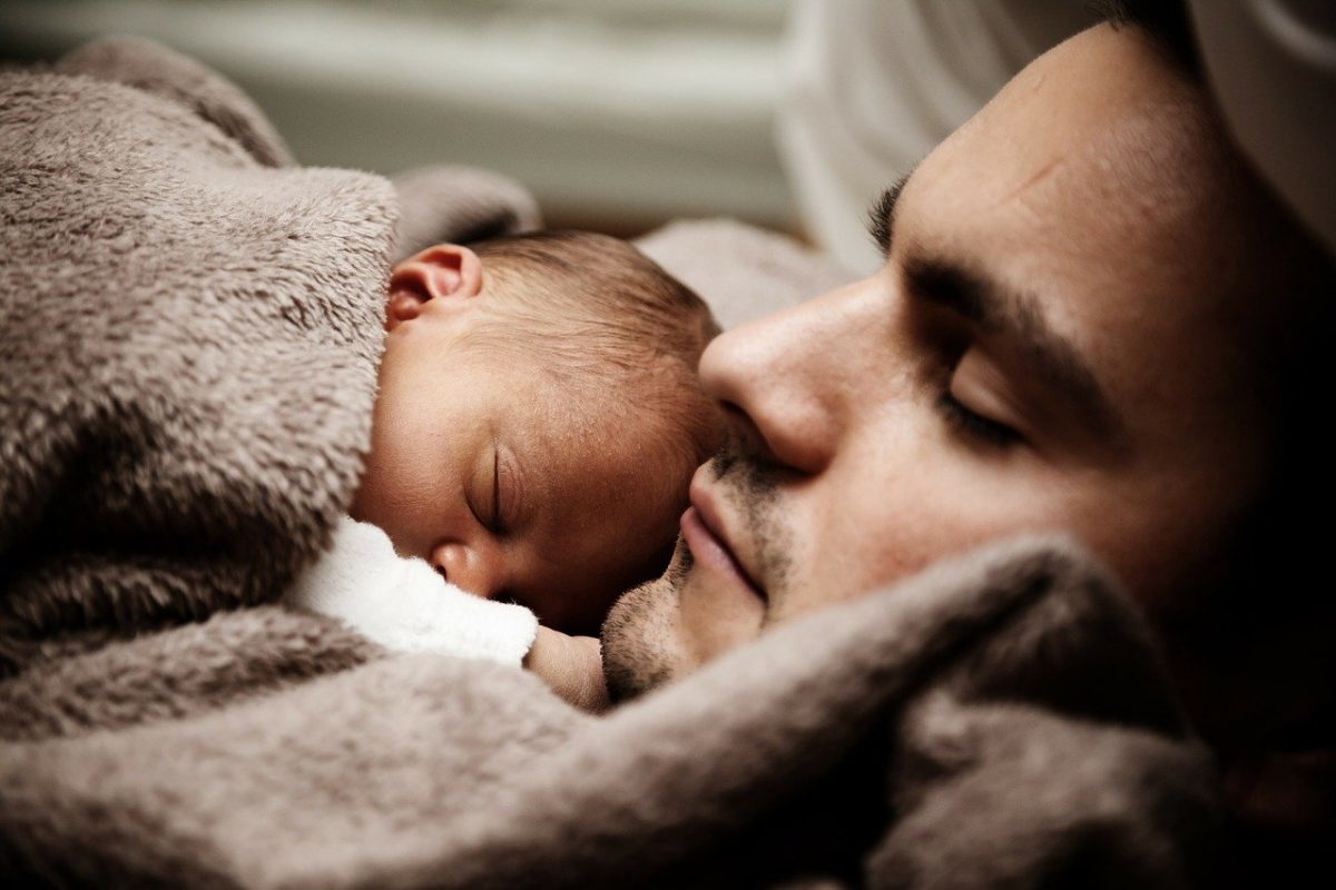 papa ou papa poule dormant avec son bébé couché sur lui